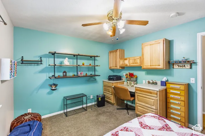 Built-in shelving units, wall-mounted cabinetry, and a ceiling fan with integrated lighting
