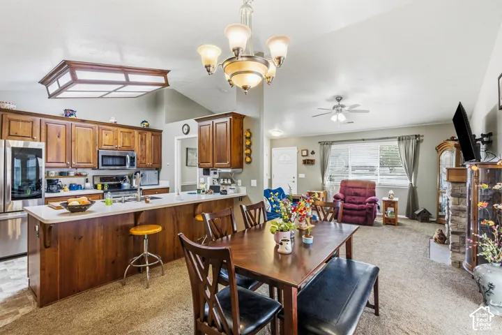 Kitchen and living area featuring a vaulted ceiling and an integrated kitchen island with a white countertop