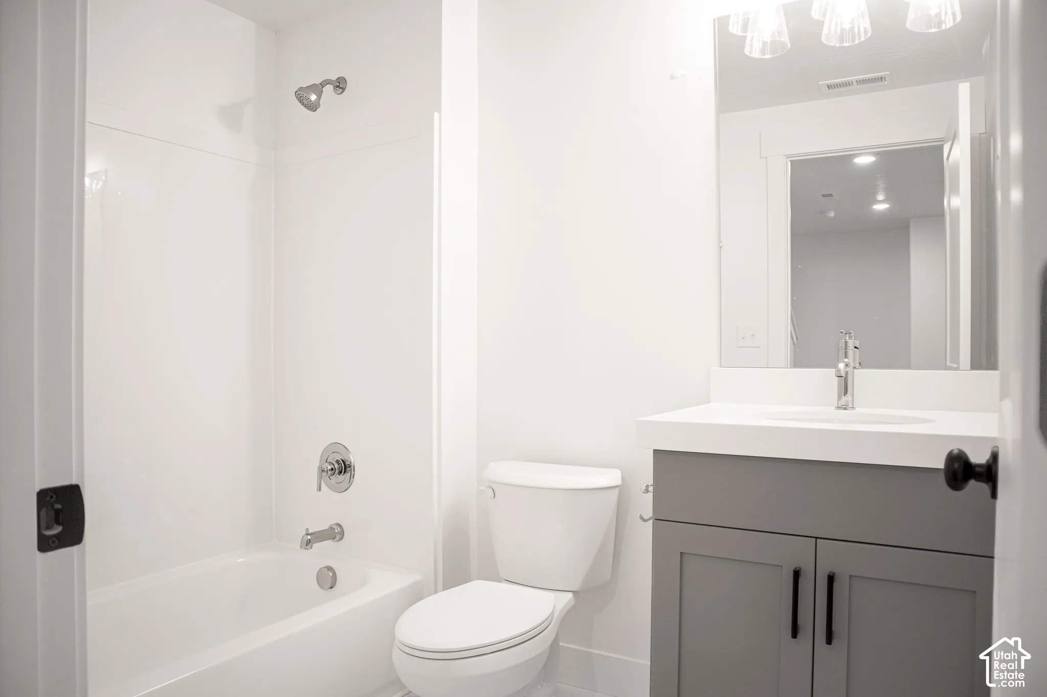 Third full bath in fully-finished basement with painted wood cabinet and quartz slab countertop.