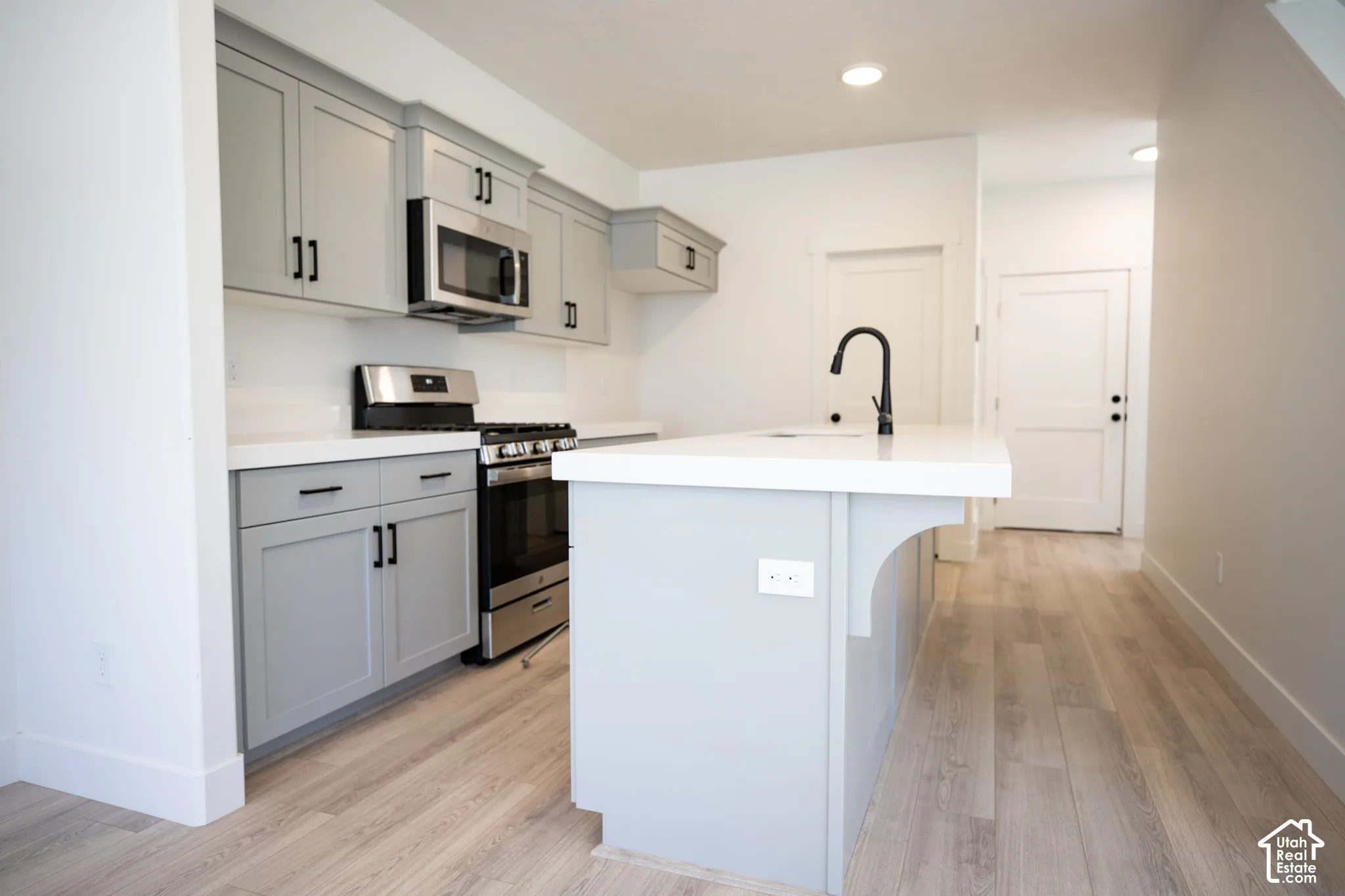 Terrific kitchen with painted wood cabinets, quartz slab countertops, walk-in pantry, gas range, microwave, dishwasher and disposal.
