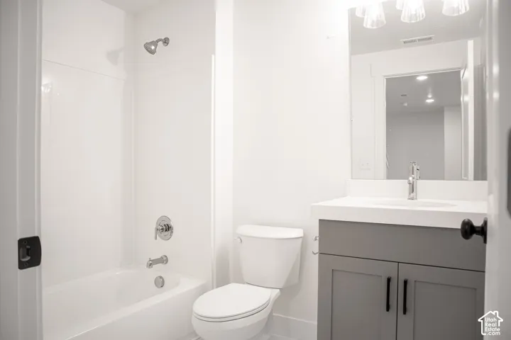 Third full bath in fully-finished basement with painted wood cabinet and quartz slab countertop.