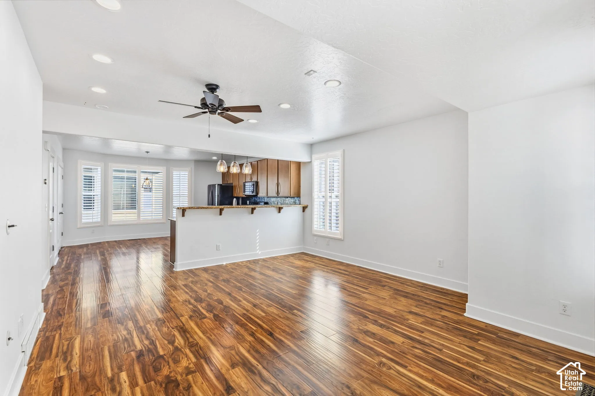 Open concept living space featuring wood-finish flooring, recessed lighting, and a ceiling fan