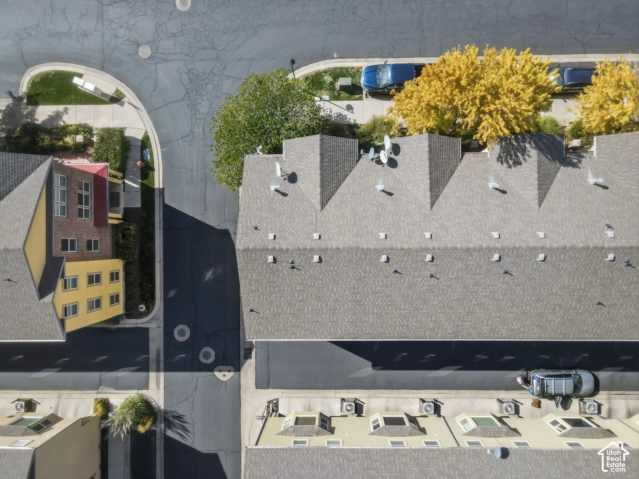 Row of townhomes with gray shingle roofs and multiple skylights