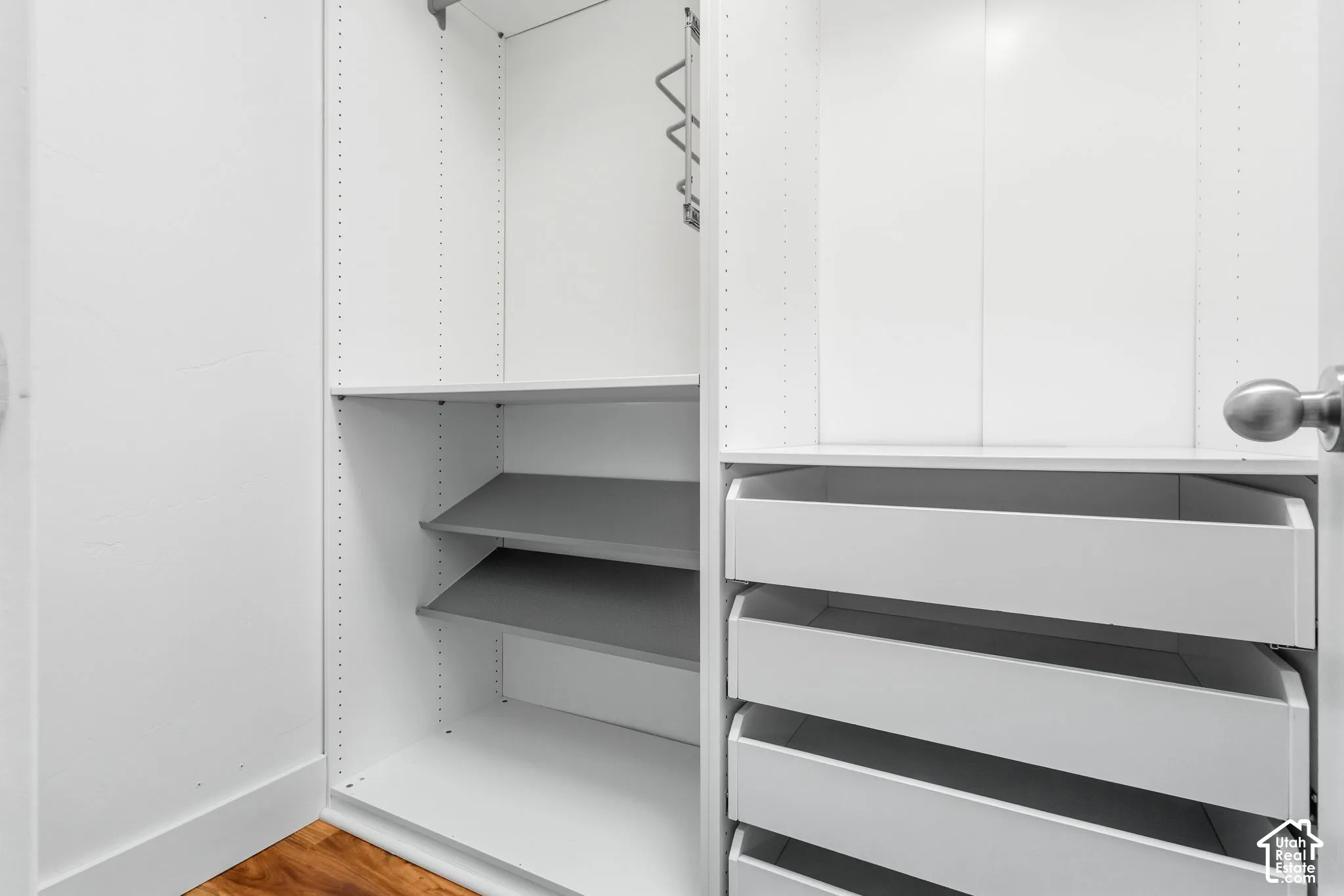 Built-in closet system featuring adjustable shelving, multiple pull-out drawers, and a hanging rod