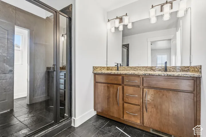 Dual vanity with stone countertop, wood cabinetry, and dual undermount sinks