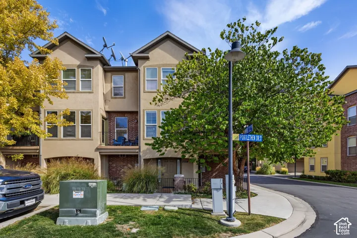 Multi-story exterior with a stucco finish and brick accents