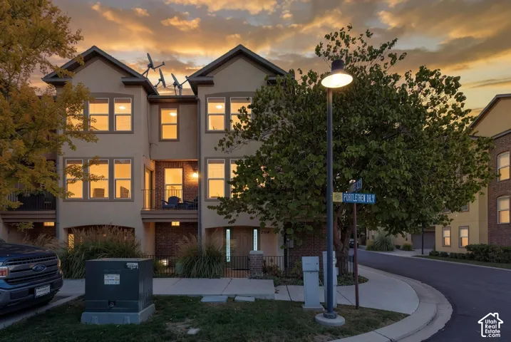 Three-story townhome with neutral stucco and brick accents