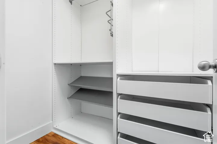 Built-in closet system featuring adjustable shelving, multiple pull-out drawers, and a hanging rod