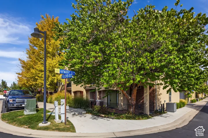 Two-story residential units with stucco exteriors, mature trees, and concrete sidewalks
