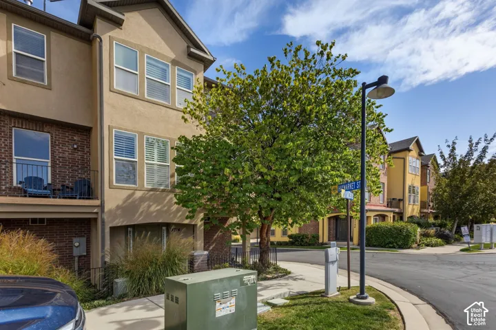 Stucco and brick exterior with a private balcony featuring a metal railing