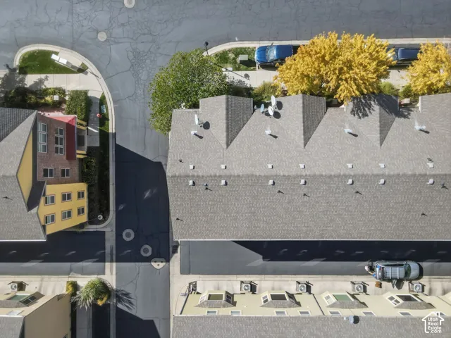 Row of townhomes with gray shingle roofs and multiple skylights
