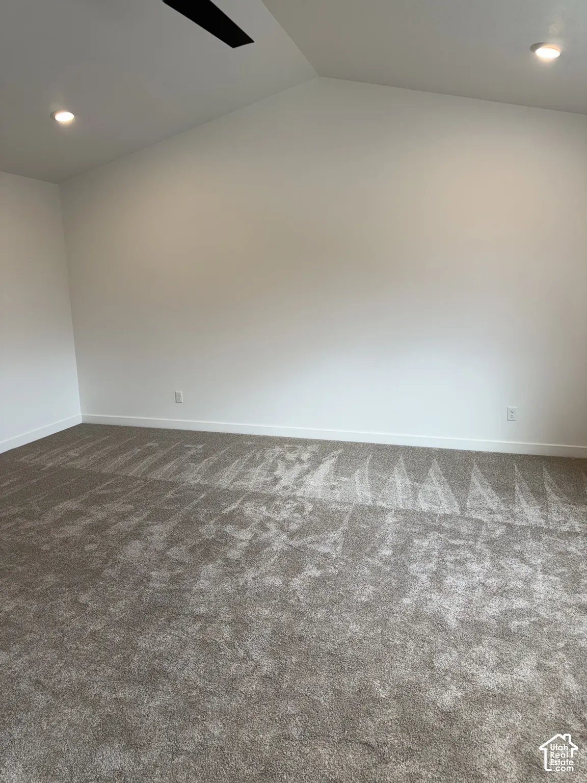 Vaulted ceiling with a black ceiling fan, recessed lighting, white walls, and gray carpet flooring