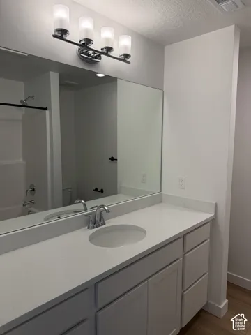 Vanity featuring a single undermount sink, a chrome faucet, and a light-toned countertop