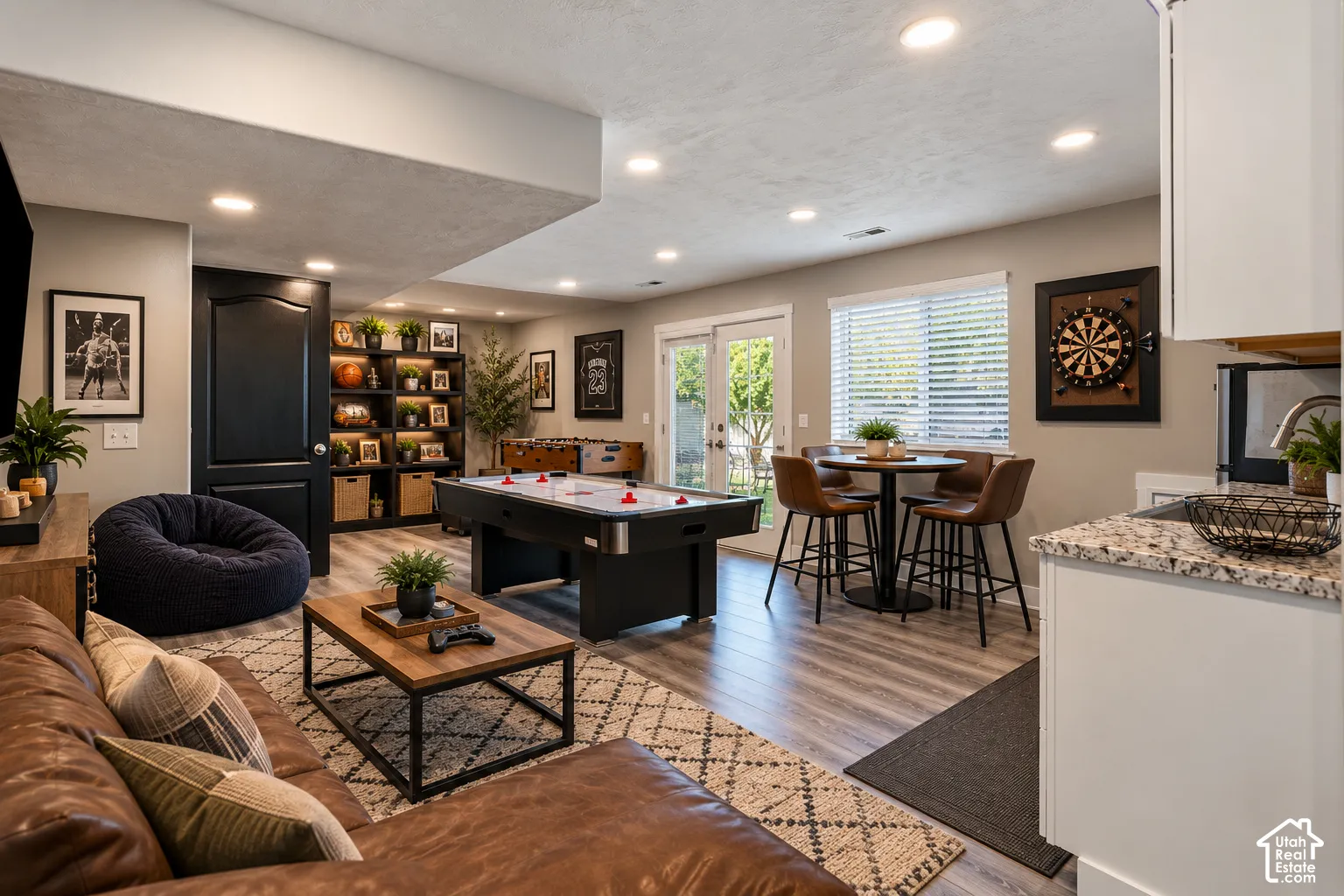 Recessed lighting throughout, built-in shelving with integrated lighting, wood-finish flooring, sliding glass door, and granite-look countertops