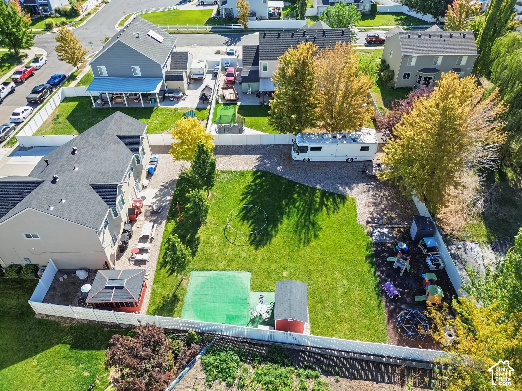 Expansive green lawn with a white privacy fence
