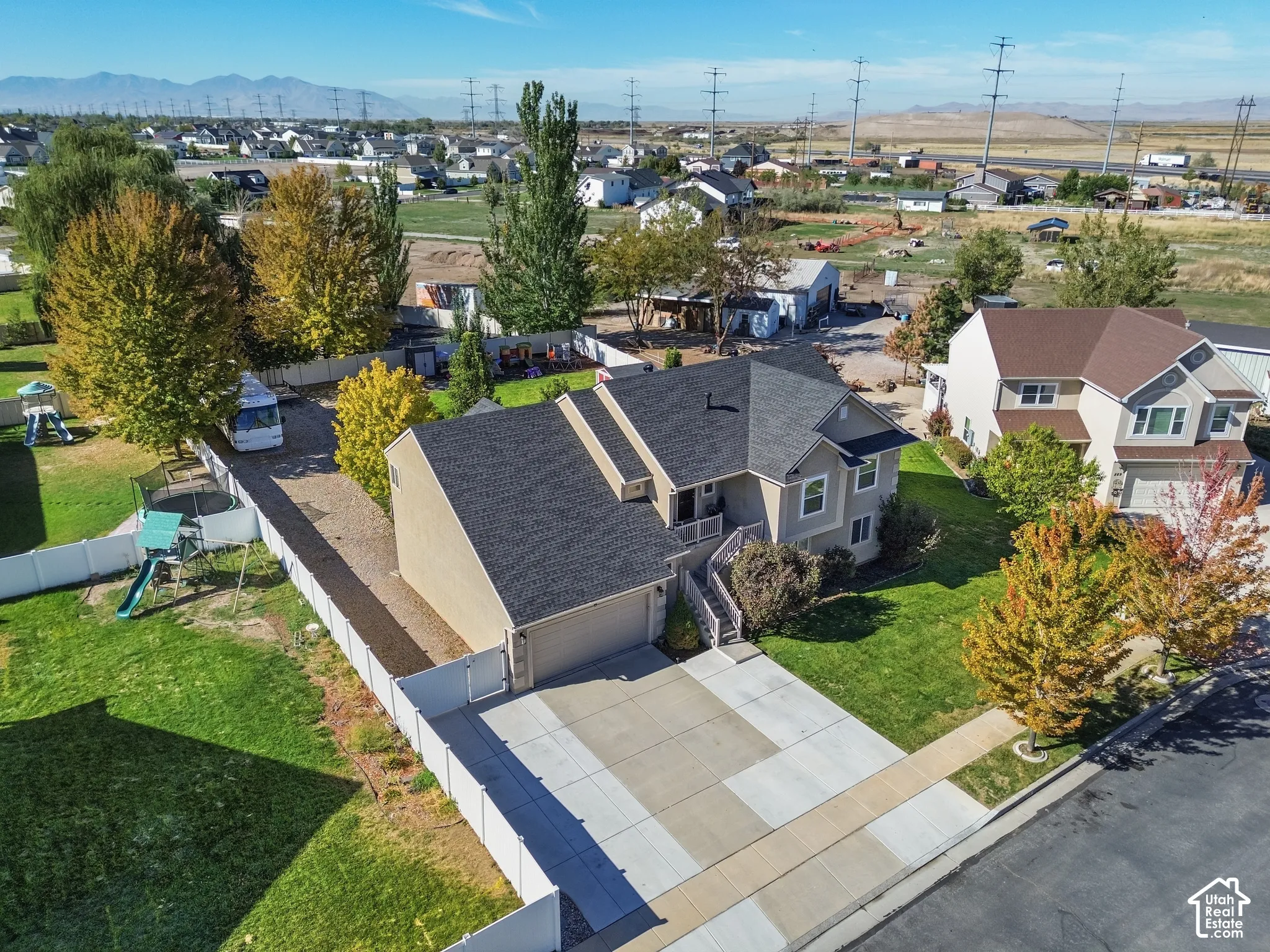 Two-story residence with a two-car garage, concrete driveway, and a fenced yard