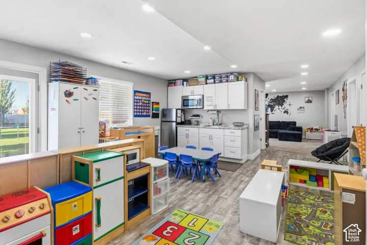 Recessed lighting illuminates the open-concept room featuring wood-finish flooring