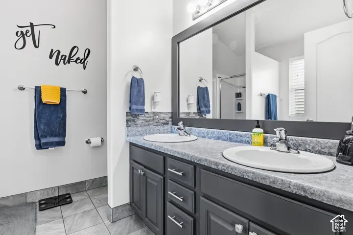 Dual vanity with undermount sinks, gray cabinetry, and a textured countertop