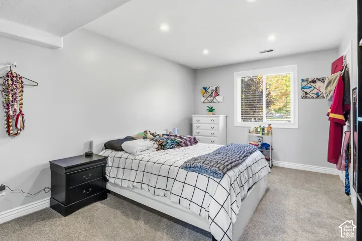 Recessed lighting, carpet flooring, a window with horizontal blinds, and painted walls
