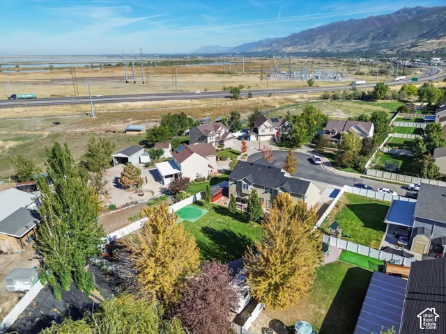 Residential development with mountain backdrop, fenced backyards, and mature trees