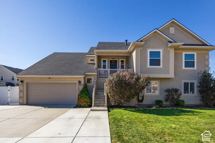 Stucco exterior featuring multiple windows and a gray asphalt shingle roof