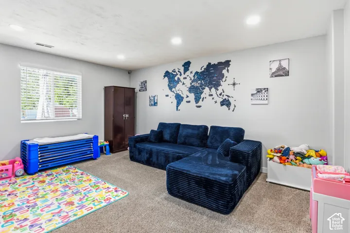 Recessed lighting, window with blinds, light gray wall paint, and gray carpet flooring