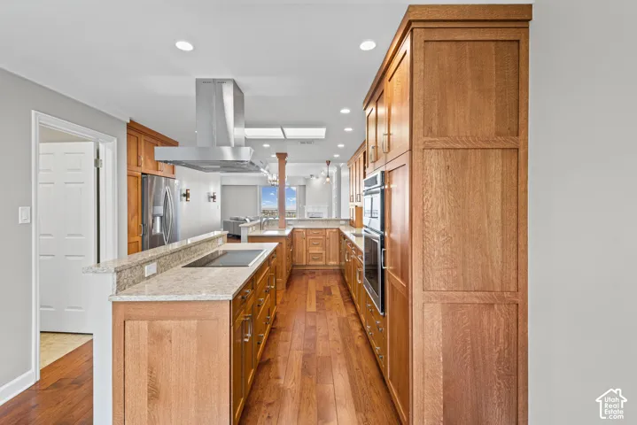 Full-height wood cabinetry, granite countertops, stainless steel appliances, wood-finish flooring, and recessed lighting