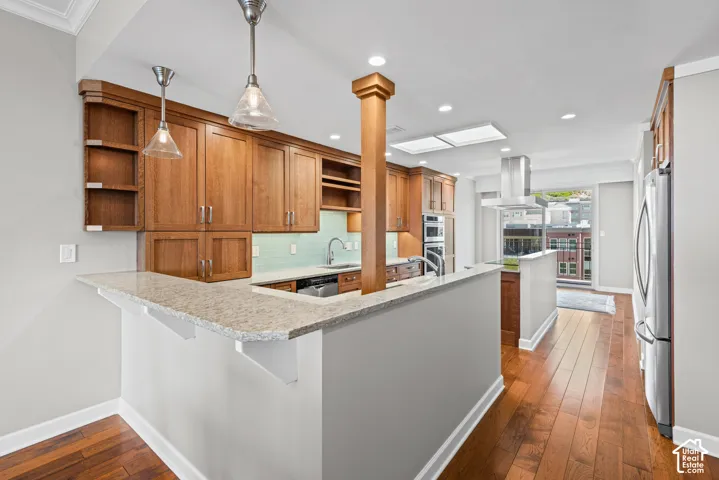 Kitchen featuring wood-finish flooring, recessed lighting, and upper and lower wood cabinetry