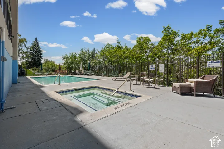 Outdoor swimming pool with integrated spa and concrete surround