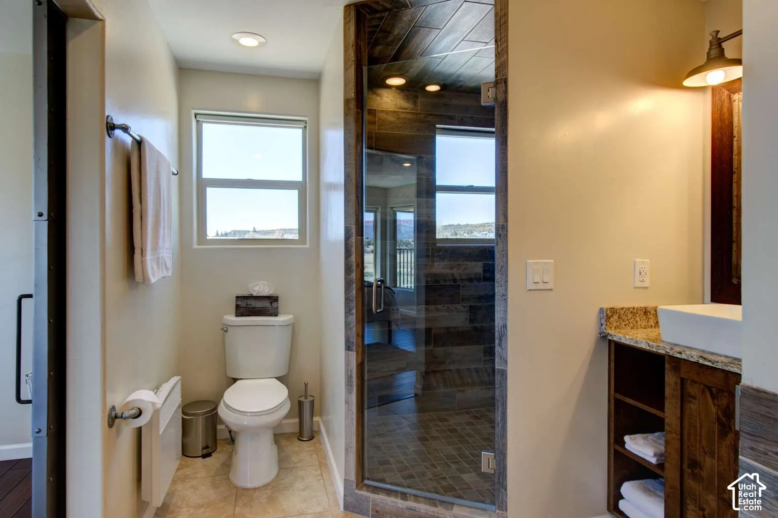 Shower with glass enclosure, wood-finish tile, and recessed lighting