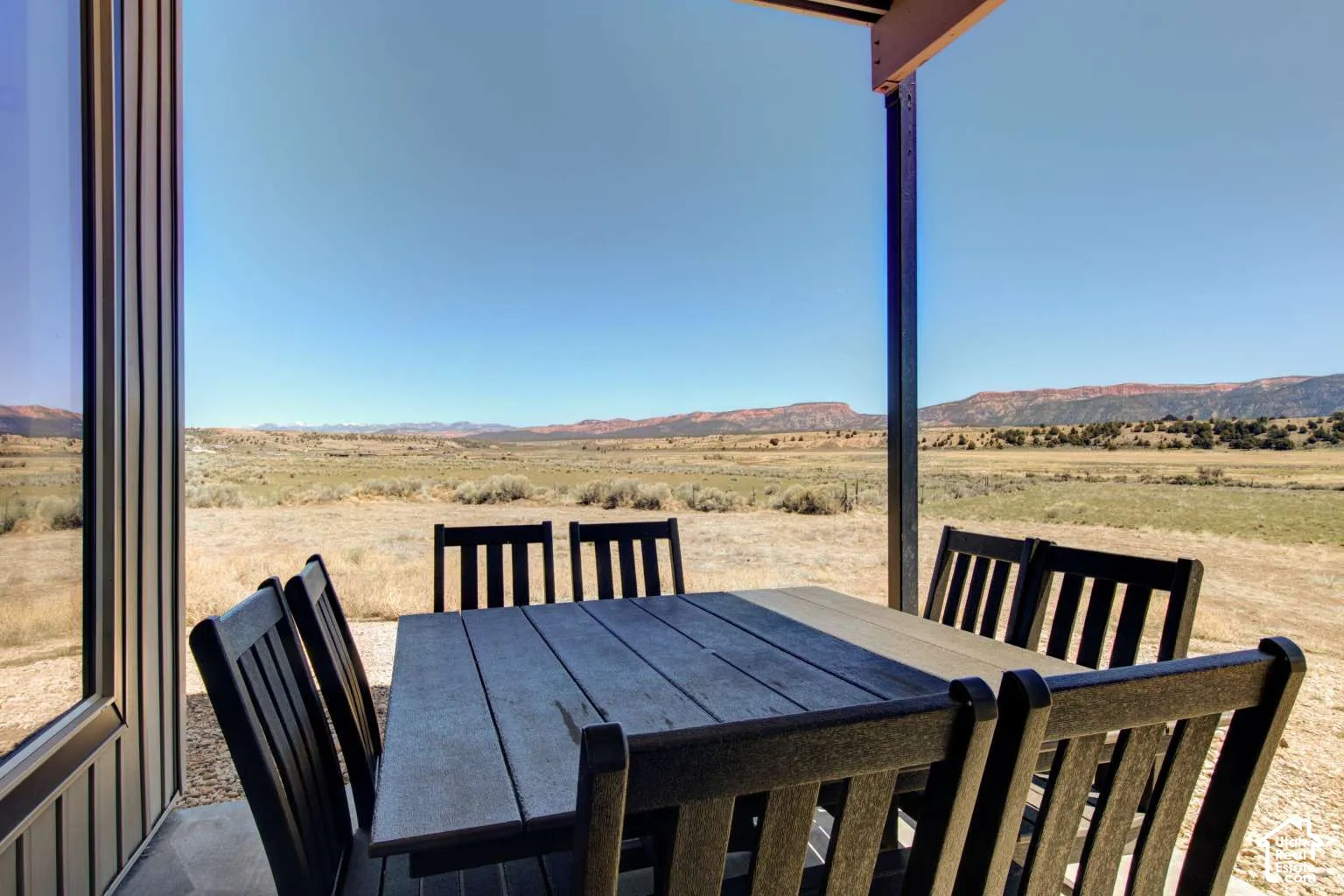 Patio with a concrete surface, expansive desert scenery, and distant mountain ranges