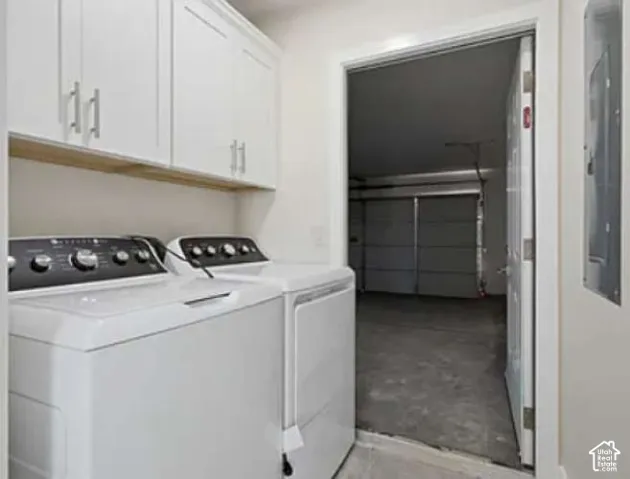 White cabinetry with brushed nickel hardware, open shelving, and a doorway leading to a garage with an overhead door