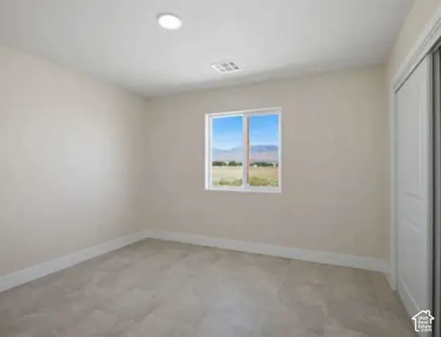 Recessed ceiling light, white window framing, mountain scenery, tile flooring, and sliding closet doors