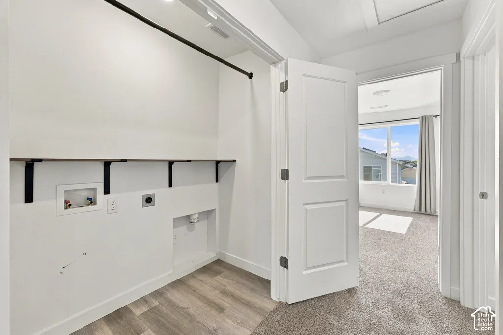 Dedicated laundry area with wood-finish shelving and a hanging rod