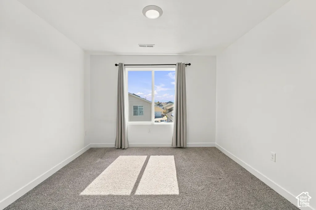 Recessed lighting fixture, plush carpeting, and a window with a curtain rod