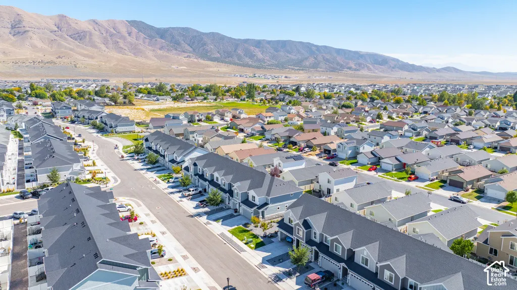 Expansive residential development featuring a variety of architectural styles, paved streets, and mountainous backdrop