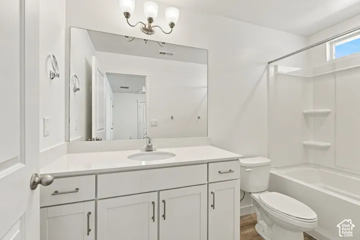 White vanity with shaker-style cabinetry, a single basin sink, and a large wall-mounted mirror