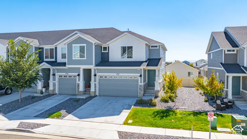 Modern multi-level exterior with a two-car garage, stone accents, and a covered entry