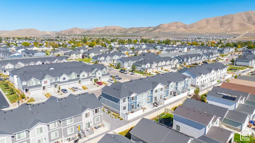 Residential development featuring multi-level townhomes with attached garages and paved driveways