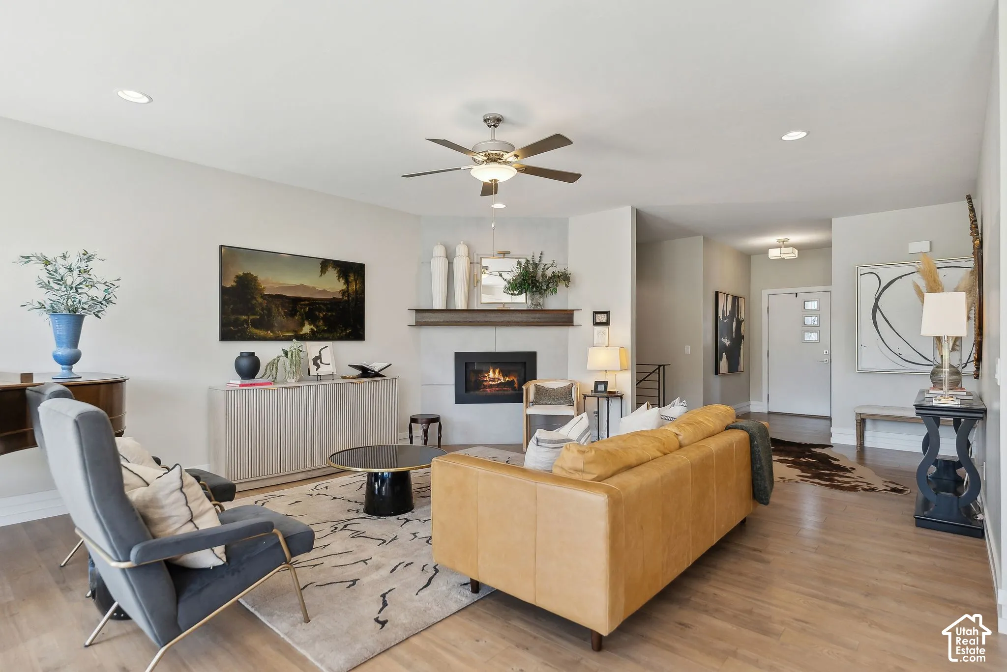 Light-toned wood-finish flooring, recessed lighting, and a ceiling fan with integrated lighting