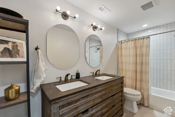 Dual oval mirrors above a rustic wood-finish vanity with two integrated sinks