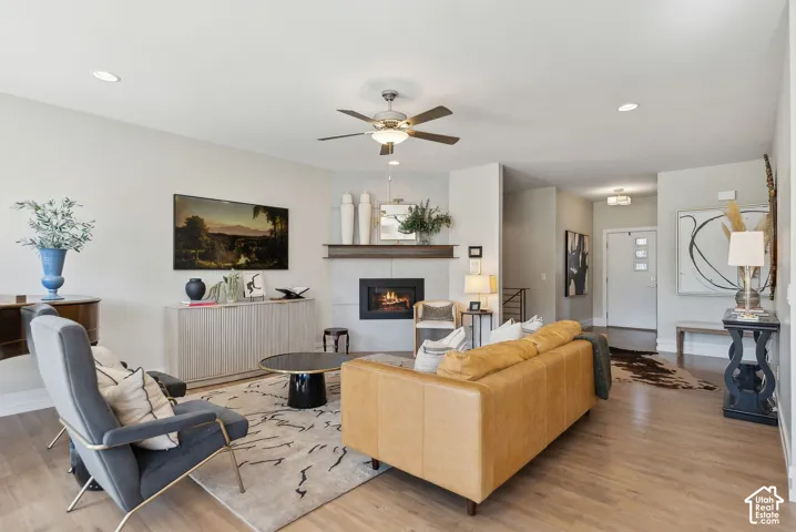 Light-toned wood-finish flooring, recessed lighting, and a ceiling fan with integrated lighting