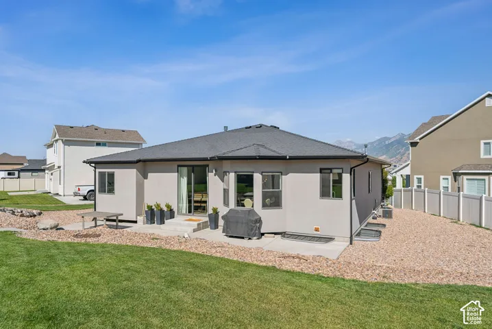 Expansive backyard featuring a manicured lawn, gravel landscaping, and a concrete patio