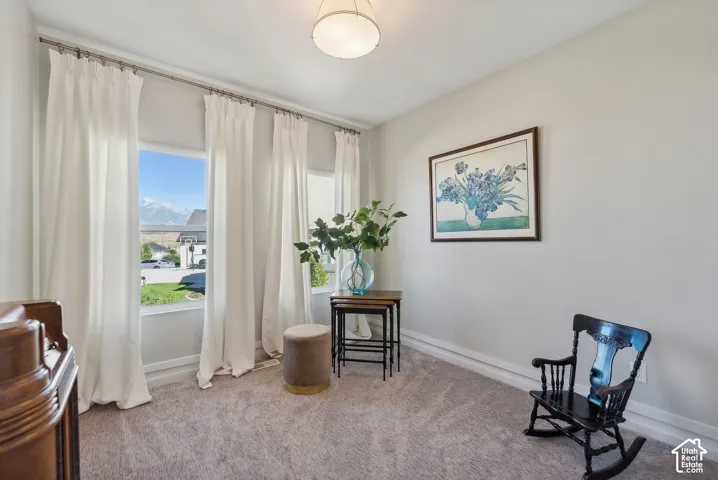 Recessed lighting, large windows, mountain scenery, light-toned walls, and carpet flooring