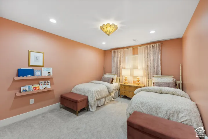 Carpeted room featuring recessed lighting, a decorative ceiling fixture, and a window with sheer and patterned drapes