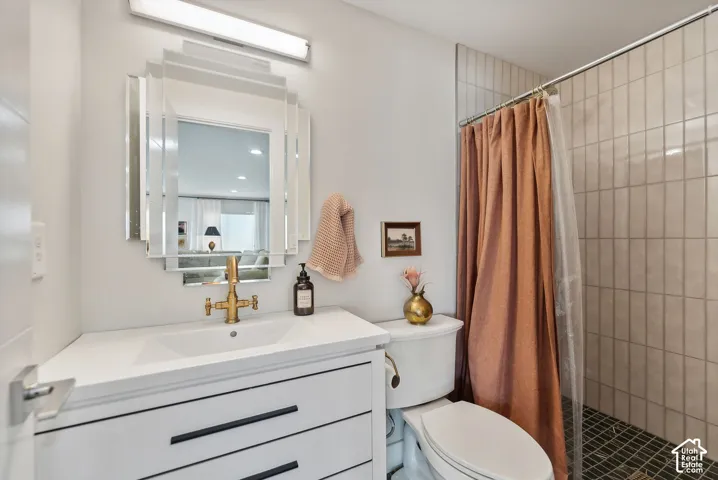 White vanity with black hardware, integrated sink, and brass-finish faucet