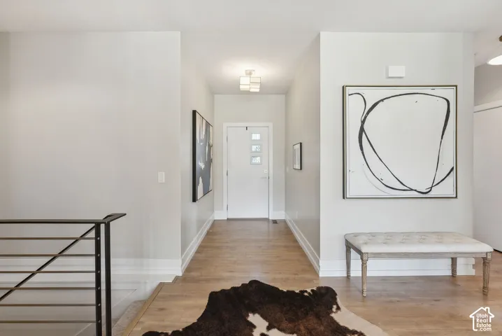 Entryway featuring wood-finish flooring, white trim, and a contemporary ceiling light fixture