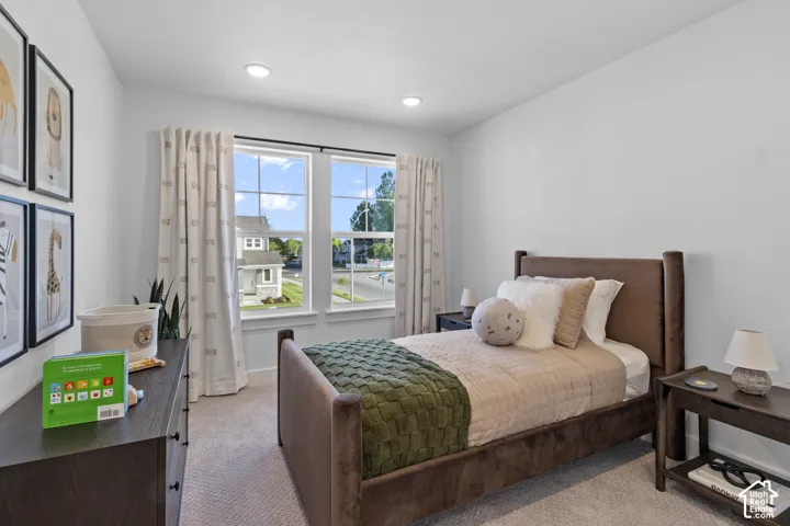 White walls with recessed lighting, two large windows, and carpeted flooring