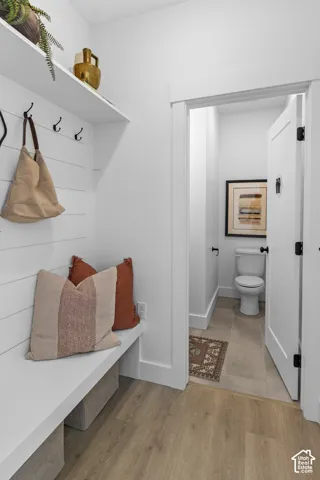 Built-in bench with a storage shelf, wall-mounted hooks, and shiplap paneling