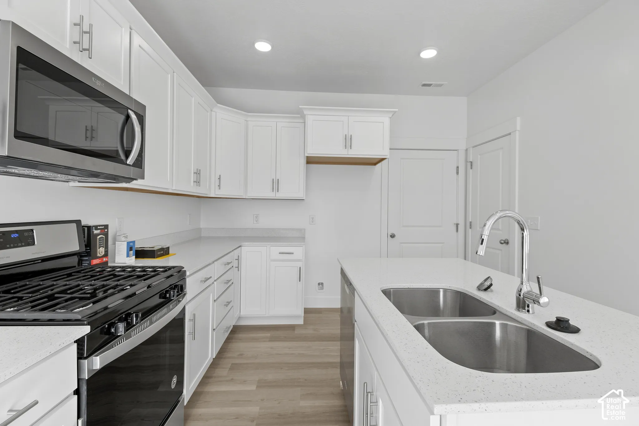 Modern kitchen featuring white cabinetry and light-toned countertops